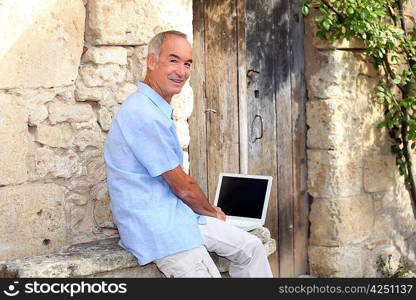 Senior man using a laptop with a blank screen