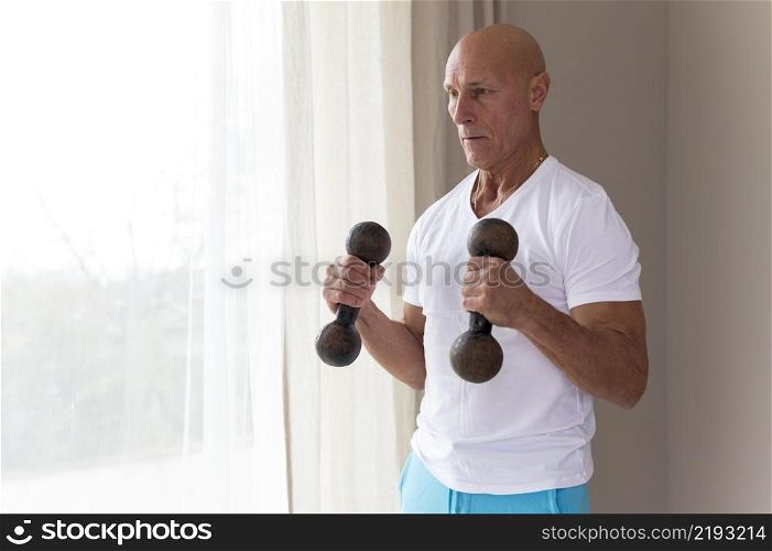 senior man using fitness dumbbells