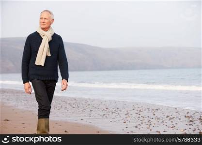 Senior Man Walking Along Winter Beach