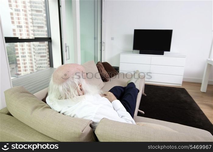 Senior man watching television in apartment