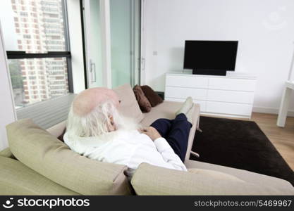 Senior man watching television in apartment