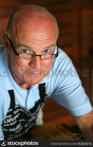 senior man wearing an apron