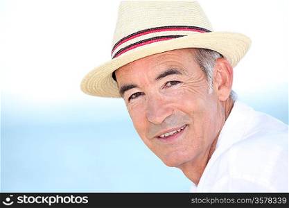 Senior man wearing at hat by the coast