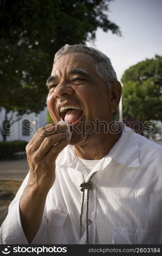 Senior man wiping face, outdoors