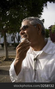 Senior man wiping face, outdoors