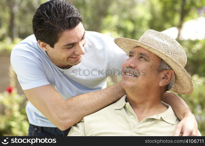 Senior Man With Adult Son In Garden