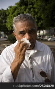 Senior man with allergy symptoms, outdoors