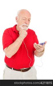 Senior man with an mp3 player, trying to figure out how to work it. Isolated on white.