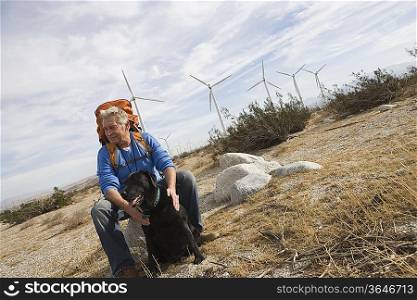 Senior man with backpack near wind farm