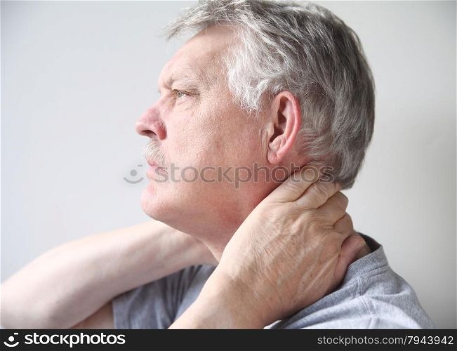 senior man with both hands on his neck