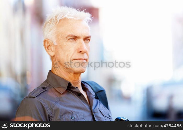 Senior man with camera in city. Looking for good shoots