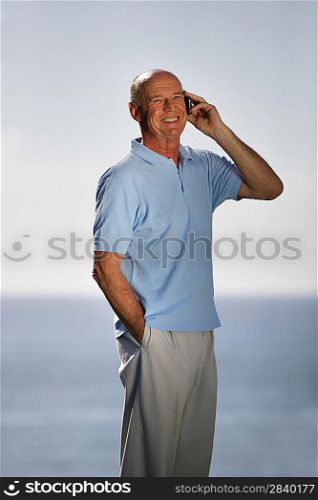 Senior man with cellphone stood by pool