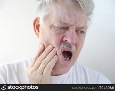 senior man with hand on his painful cheek