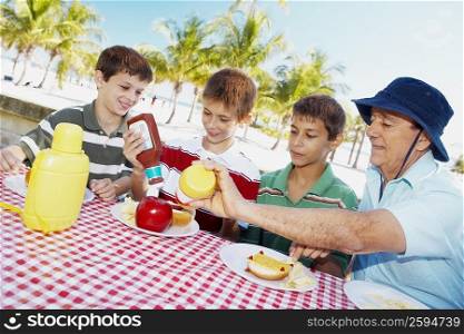 Senior man with his grandchildren sitting a table