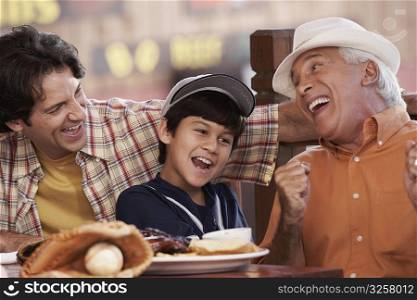 Senior man with his son and grandson sitting in a restaurant