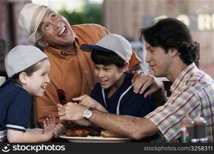 Senior man with his son and two grandchildren smiling