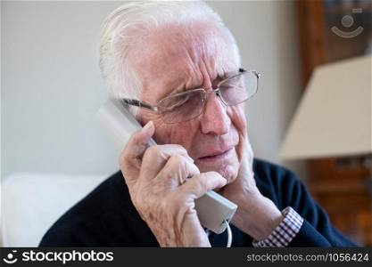 Senior Man With Neck Pain Phoning To Make Apoointment With Doctor