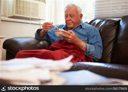 Senior Man With Poor Diet Keeping Warm Under Blanket