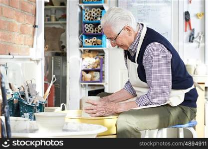 Senior Man Working At Pottery Wheel In Studio