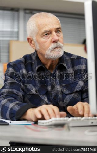 senior man working on computer at home