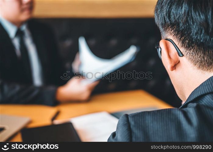 Senior manager reading a resume during a job interview employee young man meeting Applicant and recruitment concept