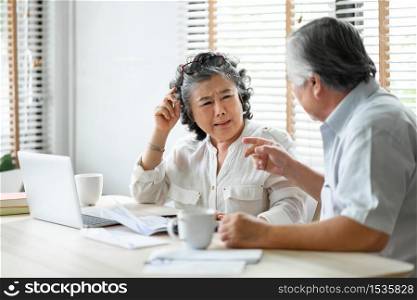 Senior mature man and woman having problem talk about family Financial crisis. Stressed old Asian Couple discussing and calculate budget, Debts, monthly expenses at home
