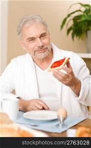 Senior mature man - breakfast at home with coffee and egg