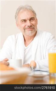 Senior mature man - breakfast at home with orange juice, coffee and egg