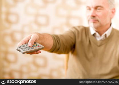 Senior mature man holding remote control in hand