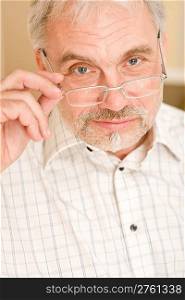 Senior mature man thoughtful with glasses looking at camera
