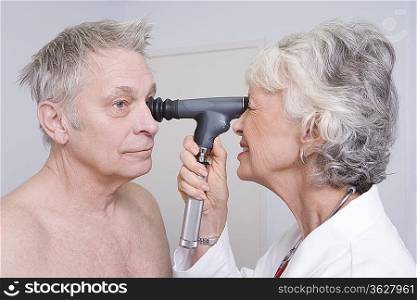 Senior medical practitioner examines man for sight test