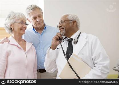 Senior medical practitioner on the phone with a senior couple