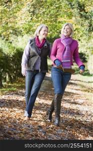 Senior mother and daughter walking on path outdoors