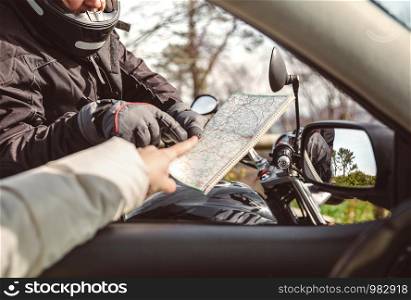 Senior motorcyclist asking to car driver the direction on road map. Motorcyclist asking to map direction