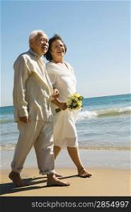 Senior Newlyweds Walking Along Beach