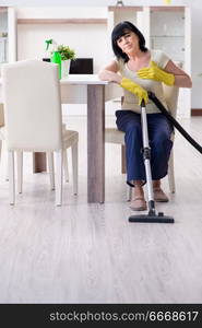 Senior old woman tired after vacuum cleaning house