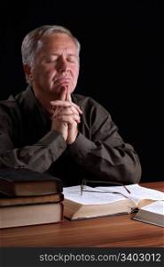 Senior pastor meditating and searching guidance in prayer