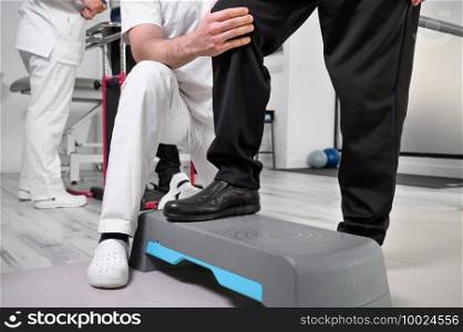 Senior Patient and physical therapist in rehabilitation walking exercises. High quality photo. Senior Patient and physical therapist in rehabilitation walking exercises.