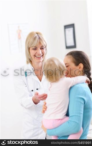 Senior pediatric doctor talking with mother and baby