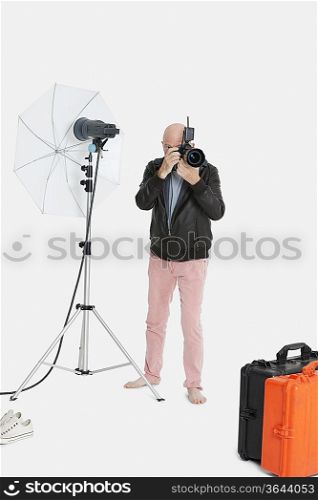 Senior photographer taking a photograph in studio