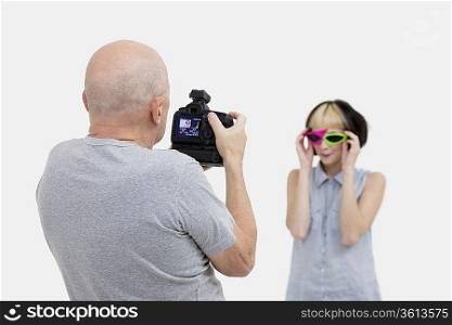 Senior photographer taking a photograph of fashion model during photo shoot