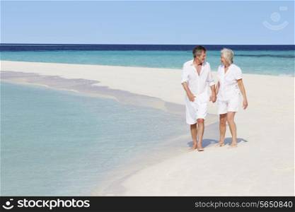 Senior Romantic Couple Walking On Beautiful Tropical Beach