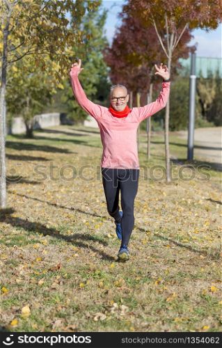 Senior runner man arms up after running