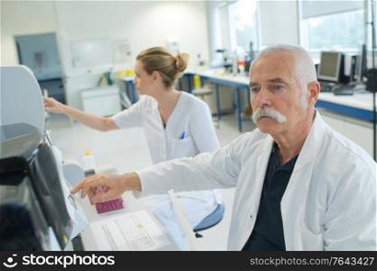 senior scientist looking at slide at the laboratory