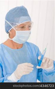 Senior surgeon female hold syringe in protective operation uniform mask