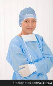 Senior surgeon female in protective operation overall uniform and mask