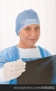 Senior surgeon female in protective operation overall uniform and mask