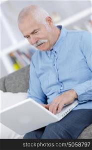 senior using a laptop at home