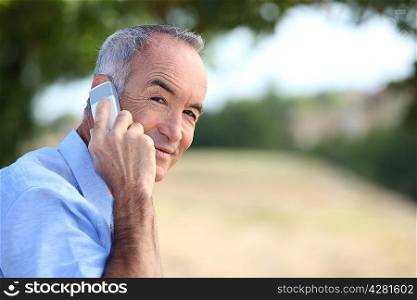 senior walking outdoors and talking on the phone