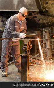 senior welder working and protective equipment with spark welding